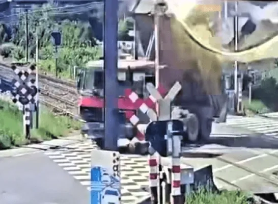 Vrachtwagen rijdt aan spooroverweg in Groot-Bijgaarden met laadbak omhoog tegen bovenleiding Vrachtwagen rijdt aan spooroverweg in Groot-Bijgaarden met laadbak omhoog tegen bovenleiding