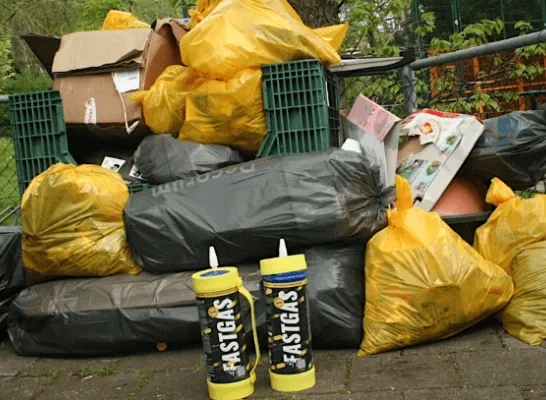 Lachgasflessen voor een stapel afval.