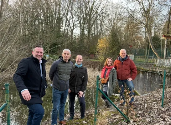 Onder andere gedeputeerde Gunther Coppens en schepen in Linkebeek Roel Leemans bezoeken de werken aan het voormalige openluchtzwembad dat een publiek park wordt