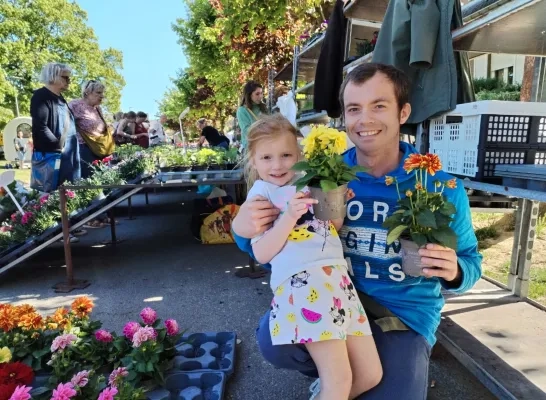 Bezoeker met kind op de bloemenmarkt in Vilvoorde