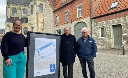 Schepen Hoefs, burgemeester Laeremans en schepen Roosen bij een informatiebord over de blauwe zone