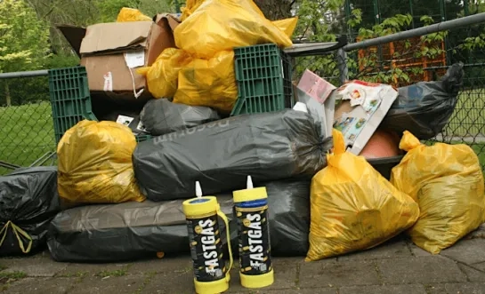 Lachgasflessen voor een stapel afval.