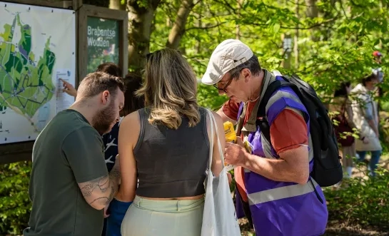 Een vrijwilliger helpt bezoekers tijdens het Hyacintenfestival