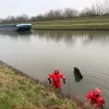 De duikers halen een auto uit het kanaal in Sint-Pieters-Leeuw